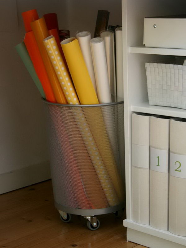 Add wheels to the bottom of a trash can for storing rolls of gift wrap. It feels super sturdy. 