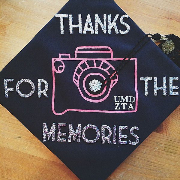 Painted Camera Graduation Cap. Stay in trend with this graduation cap painted with silver glittering wording as well as pink camera design. 