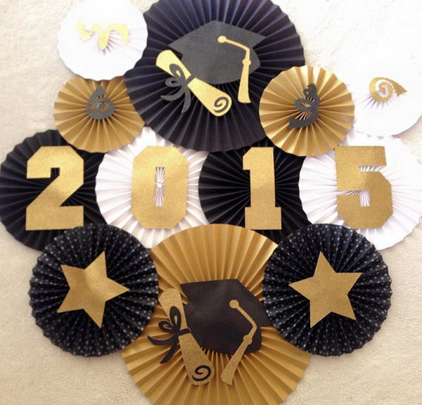 Fan Backdrop Graduation Decor. It's very necessary to create a beautiful backdrop for your graduation party. Display fans in gold, black and white to match the graduation theme. All the diploma and stars add up for graduation flavor to this backdrop. 