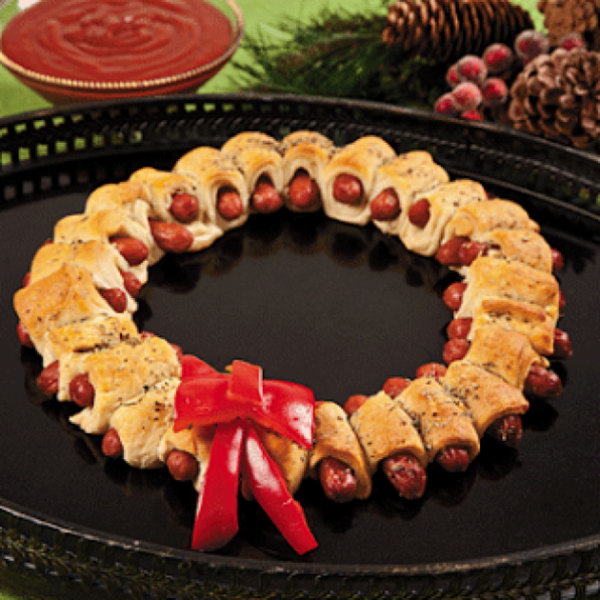 Mini Sausage Wreaths. Cutting prepared pizza into 32 pieces, wrap one strip of dough around mini sausage. Bake until the color turns gold. Add rosemary topped butter on top of the srescent wrappend sausages. Display in a wreath shape and add the bow made of red pepper for decoration to celebrate your Christmas party. 