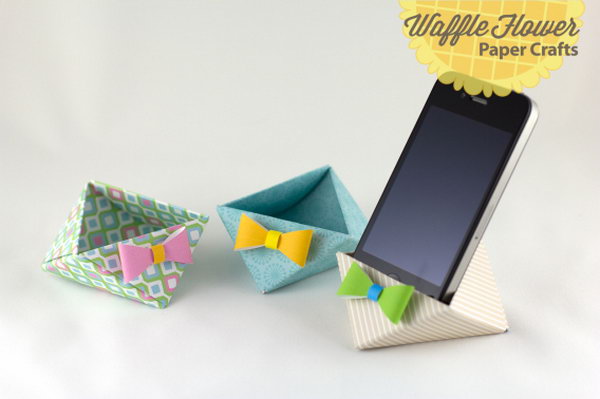 iPhone Paper Triangle Stand. Score and fold each square patterned paper, tuck each corner next to the other to create the container. Tie the bow for beautiful garnishment to finish off your paper stand in this elegant way. 