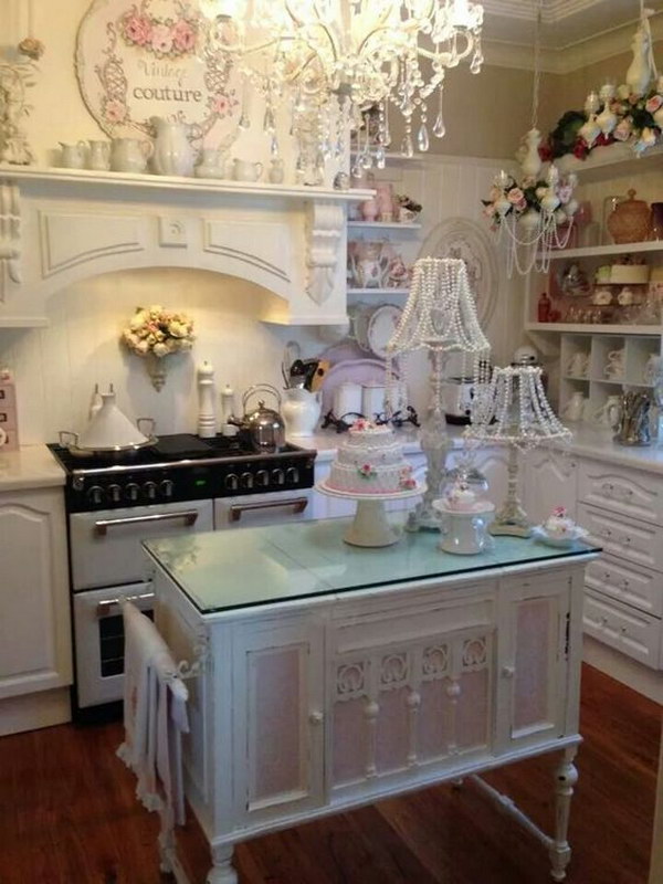 White Shabby Chic Kitchen with Small Pink Island and Beaded Lampshades. 